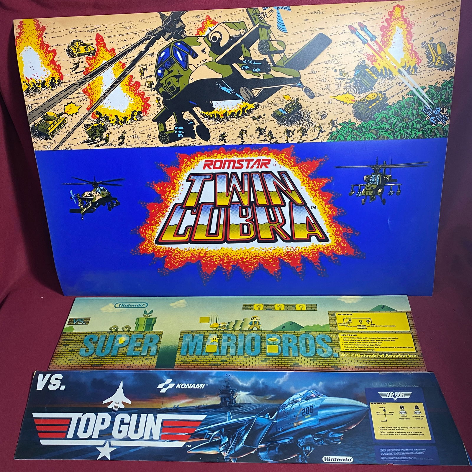 Three Arcade Game Advertisement Signs - Romstar Twin (25"x18"), Nintendo Super Mario Bros (Faded: Three Arcade Game Advertisement Signs - Romstar Twin (25"x18"), Nintendo Super Mario Bros (Faded 23"x5.75"), Konami Top Gun (24"x6")