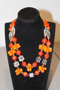 Vintage Orange glass lucite and plastic beaded necklace: A vintage orange glass, lucite, and plastic beaded necklace is a vibrant and eye-catching piece of jewelry, often reflecting mid-century design aesthetics. These necklaces typically feature a mix of m