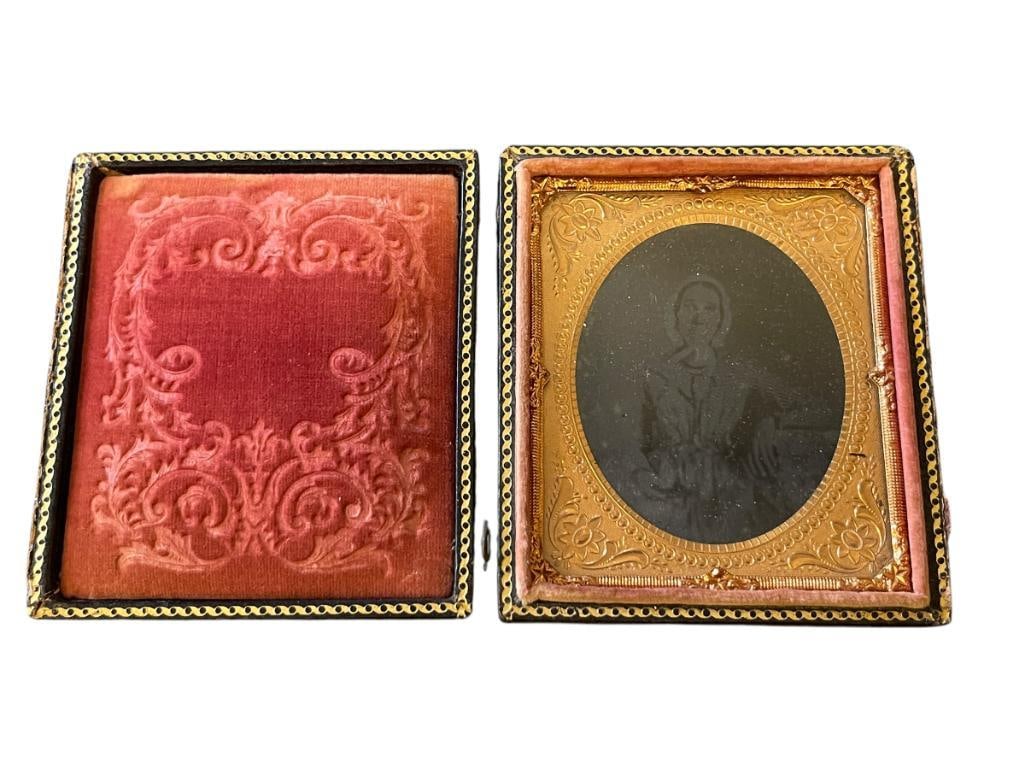 ANTIQUE DAGUERREOTYPE OF A MIDDLE AGED WOMAN IN BONNET: IN A LEATHER AND GILT FRAME, LEATHER BOOKLET HAS BROKE BUT LATCHES STILL WORK 3 1/4" X 3 3/4"