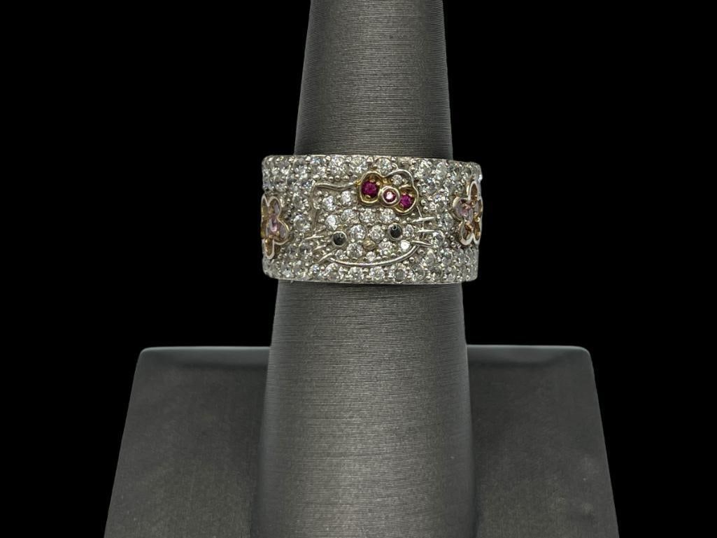 SANRIO DESIGNER HALLMARKED HELLO KITTY CZ FASHION RING: FEATURING VARIOUS COLORED CZ'S AND HELLO KITTY DESIGN, PAVE CZ'S SET AROUND BAND SIZE 7, 1/2" THICK, 7.17 GRAMS