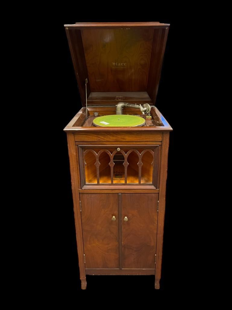 ANTIQUE STARR MAHOGANY CASE UPRIGHT PHONOGRAPH RECORD PLAYER: FEATURING INTERNAL HORN BEHIND FRETWORK DOOR, ORIGINALLY SOLD AT EINSELEN MUSIC STORES OF SAN FRANCISCO, CALIFORNIA, HAND CRANK ON RIGHT SIDE, INCLUDES VARIOUS RECORDS, OVERALL GOOD CONDITION 20"