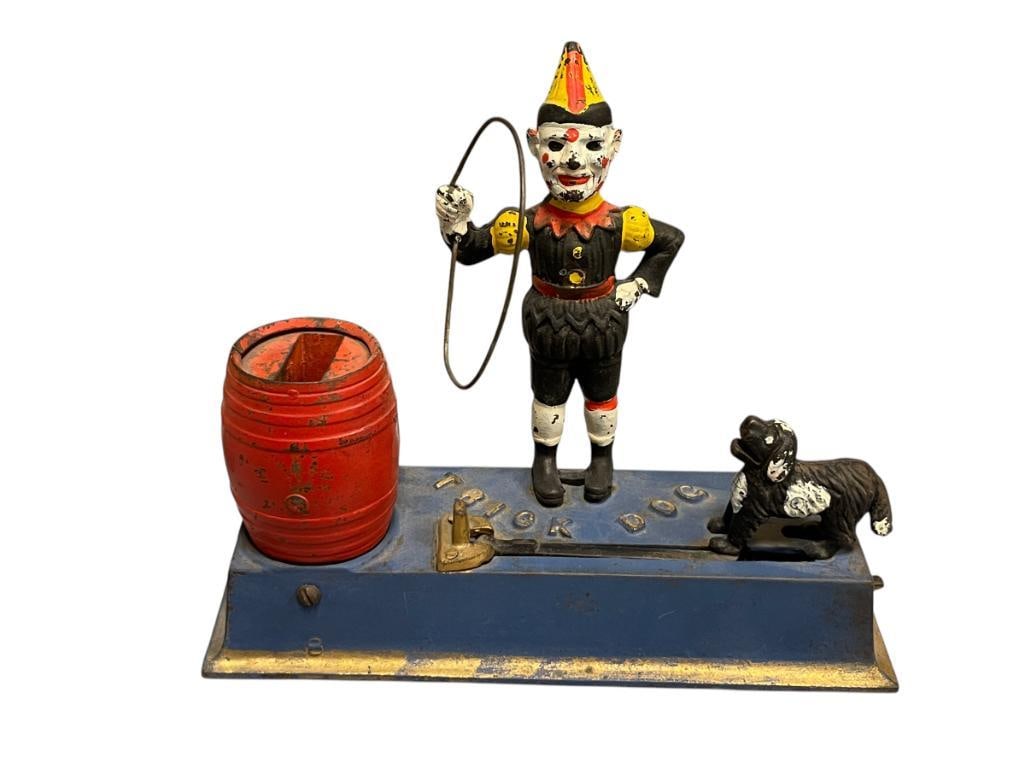 VINTAGE PAINTED CAST IRON TRICK DOG MECHANICAL COIN BANK: DOG JUMPING THROUGH HOOP INTO A BARREL COIN BANK, FUNCTIONAL 8 1/2" L