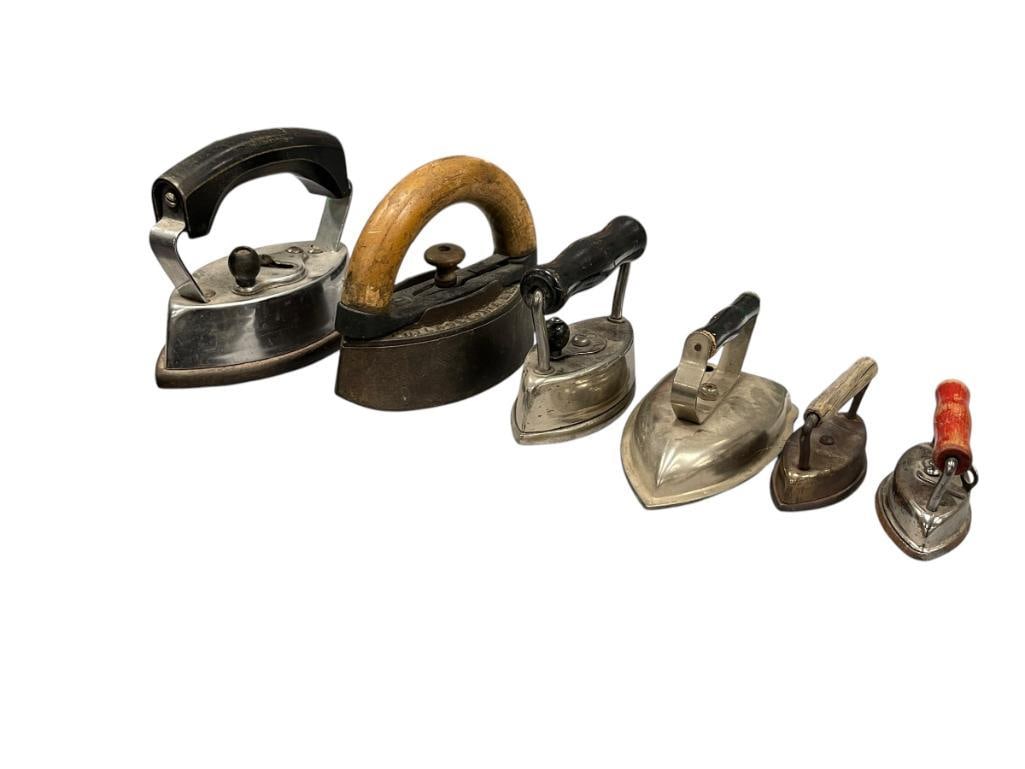 ANTIQUE AND VINTAGE CAST IRON SAD IRONS IN VARIOUS SIZES ENTERPRISE AND DOVER MAKERS: THREE MADE BY DOVER EACH WITH REMOVABLE HANDLE, AND ENTERPRISE ANTIQUE IRON WITH REMOVABLE WOODEN HANDLE, INCLUDES TWO OTHER IRONS NO MAKERS MARK 3 1/4" UP TO 6 1/2" L Â 