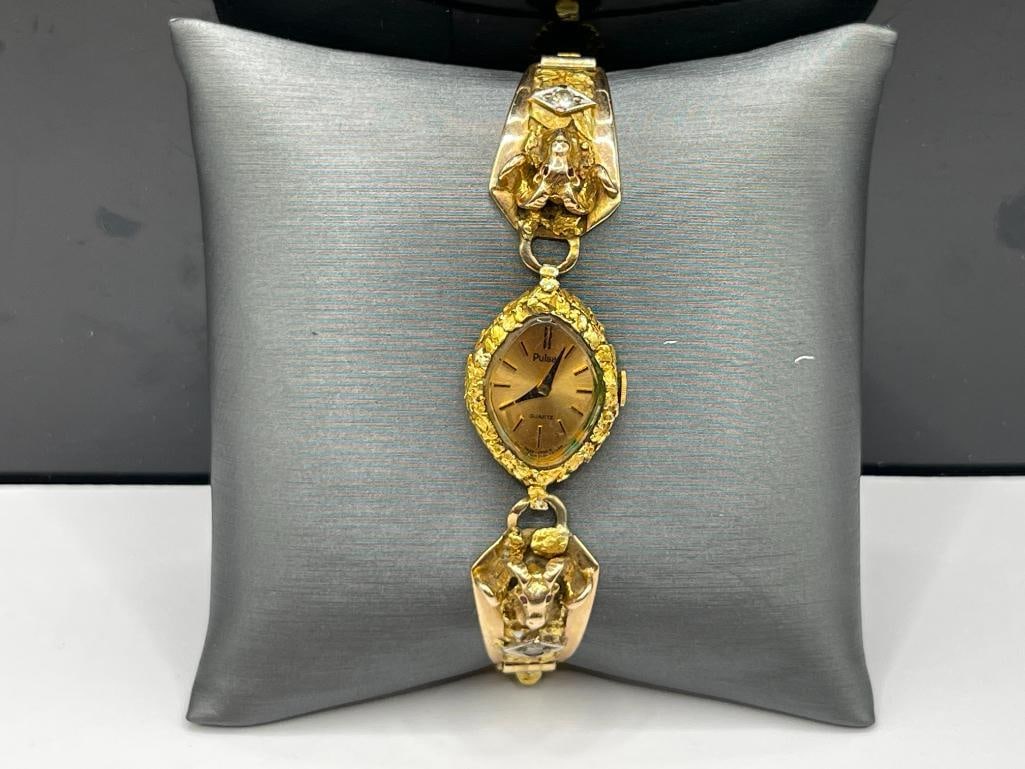 10K YELLOW GOLD WATCH BAND WITH NATURAL GOLD NUGGETS, FIGURAL RAM'S HEAD, AND DIAMONDS: FEATURES TWO ROUND BRILLIANT CUT DIAMONDS, PULSAR QUARTZ WATCH WITH GOLD NUGGETS AROUND CASE, NEEDS BATTERY, BAND IS HALLMARKED, RAM'S HEADS FEATURE RUBY EYES 27.79 GRAMS WITH WATCH, 22MM CASE, .15CTT
