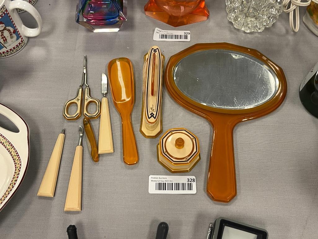 ART DECO PERIOD CELLULOID AND FRENCH IVORY VANITY SET NINE PIECES TOTAL: INCLUDES BEVELED HAND MIRROR, NAIL BUFFER, PILL BOX, SHOE HORN, VUTICLE CUTTER, ETC. 10 5/8" HAND MIRROR 7 1/2" SHOE HORN 2" PILL BOX