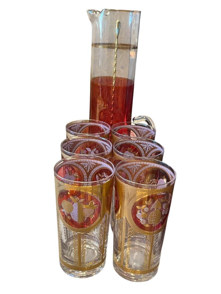 SET OF SIX CERA 22K GOLD AND CRANBERRY HIGHBALL COLLINS GLASSES WITH FRUIT MOTIF AND GLASS PITCHER: PITCHER IS 12 1/2" AND GLASSES ARE 5 1/2"