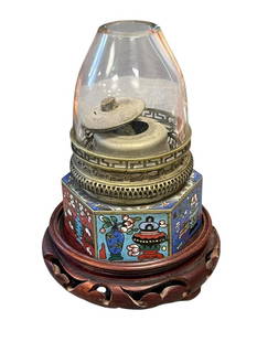 EARLY 20TH CENTURY CHINESE PAKTONG CLOISONNE ENAMELED OPIUM LAMP: CHINESE OPIUM LAMP, HEXAGONAL BASE WITH COLORFUL TRADITIONAL IMAGERY, PIERCED DECORATIVE COLLAR WITH ROUND CLEAR GLASS SHADE, CHOP MARKS ON BOTTOM, INCLUDES CARVED WOOD BASE 4 3/4" H
