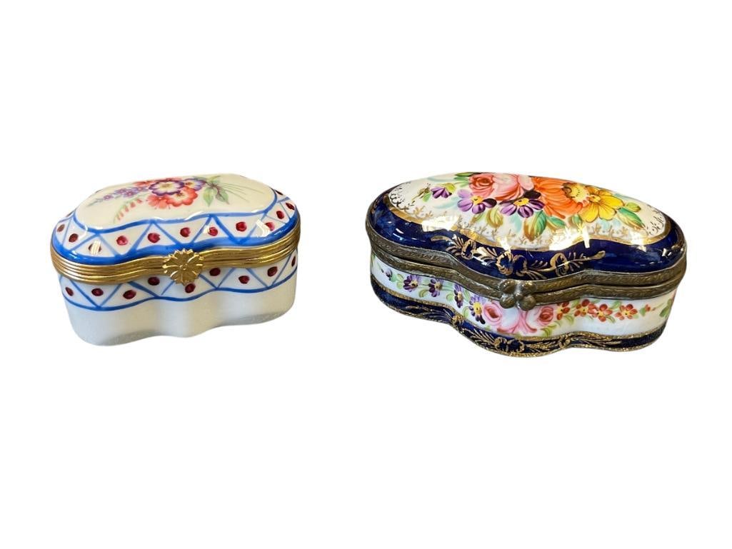 20TH CENTURY PORCELAIN HINGED PILL BOXES, ONE IS LIMOGES: TWO DECORATIVE HAND PAINTED PORCELAIN PILL BOXES WITH HINGED TOP, FLORAL DESIGN, ONE WITH GILT ACCETNS, SMALLER PIL BOX IS MARKED LIMOGES MADE IN FRANCE 2 1/2" AND 3 3/8"