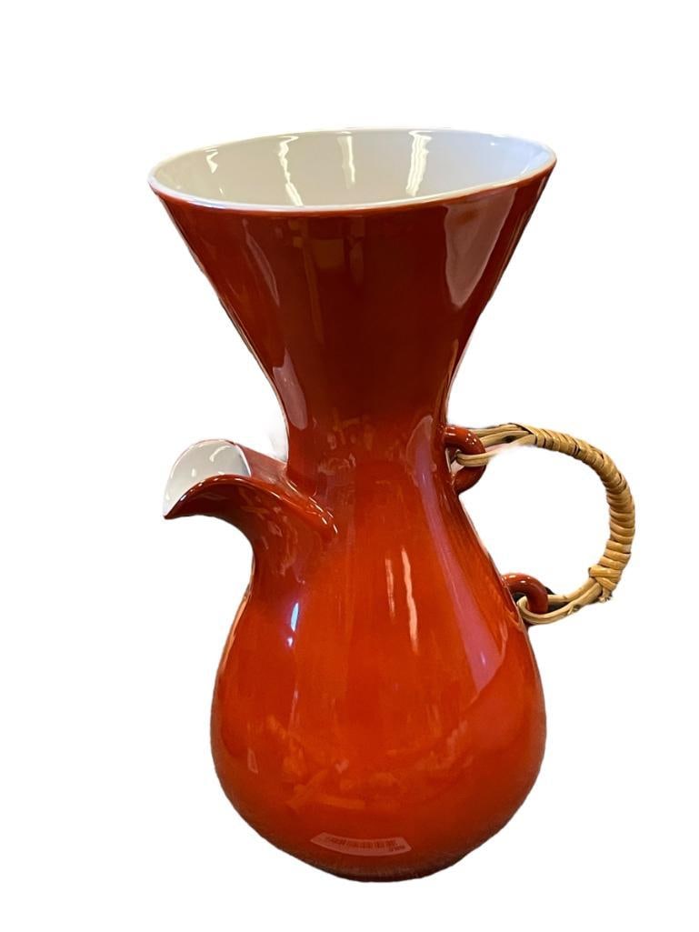 KENJI FUJITA LEDERMAN MID CENTURY MODERN PORCELAIN COFFEE CARAFE: NICE MODERNIST POT, BRIGHT ORANGE RED OUTSIDE WITH BRIGHT WHITE INSIDE, COMES WITH A RATTAN HANDLE, VERY GOOD CONDITION 11" X 6"
