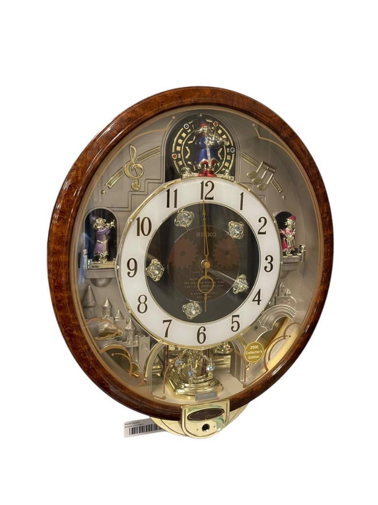 SEIKO MELODIES IN MOTION BATTERY OPERATED ANIMATED WALL CLOCK WITH SWAROVSKI CRYSTALS 2006 EDITION: PLAYS A VARIETY OF MELODIES AS THE CLOCK FACE OPENS AND ROTATES, BURL GRAIN TRIM WITH GOLD TRIM, FEATURES THREE FIGURES AS 12, 3, AND 6 NUMERAL, NOT TESTED, BATTERY TERMINALS HAVE CORROSION AND WIL NE