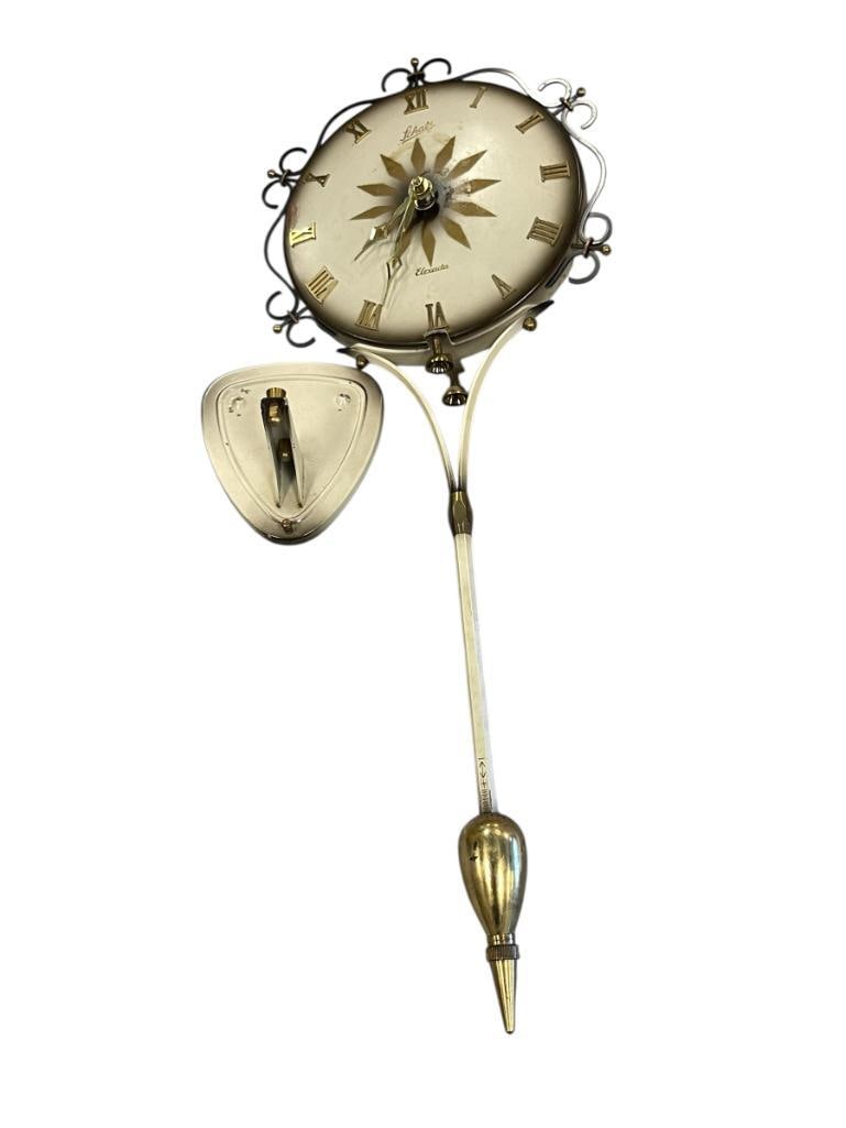 1960'S SCHATZ ELEXACTA MID-CENTURY KITCHEN CLOCK MADE IN GERMANY: IVORY AND SMOKE IN COLOR WITH BRASS FINISH ACCENTS AND ROMAN NUMERAL DIAL, BATTERY OPERATED 21" L