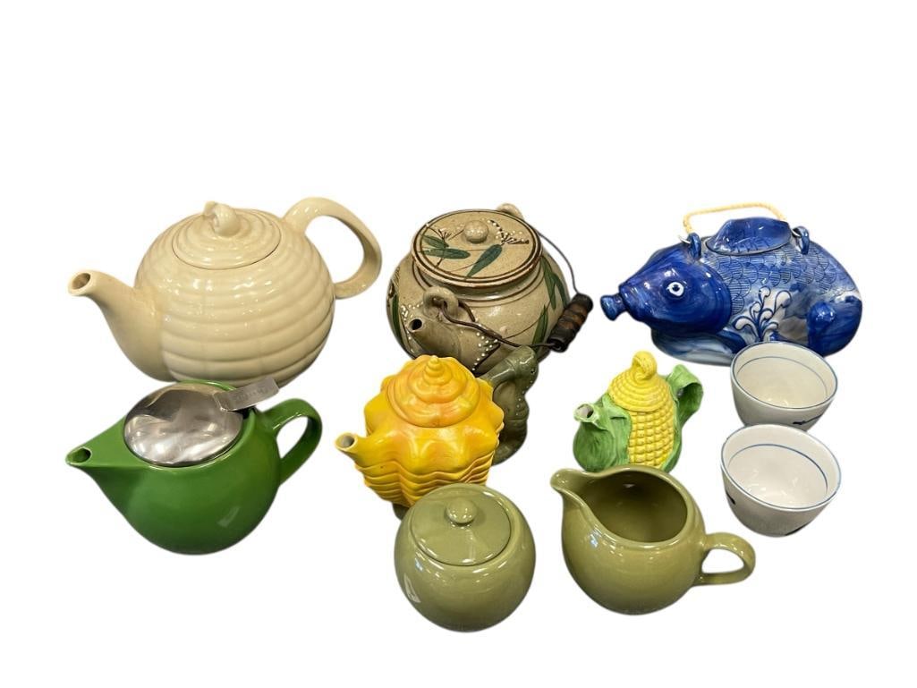 COLLECTION OF TEAPOTS INCLUDING FIGURAL TEAPOTS, CHINESE TEA CUPS, CREAMER AND SUGAR: KOI FISH PORCELAIN FIGURAL TEAPOT, CORN COB DECORATIVE TEAPOT, HORSESHOE HANDLED SEASHELL TEAPOT, BEEHIVE TEAPOT, EARTHENWARE TEAPOT, CHINESE TEACUPS, AND MATCHING CREAMER AND SUGAR 2 3/4" UP TO 9" TE