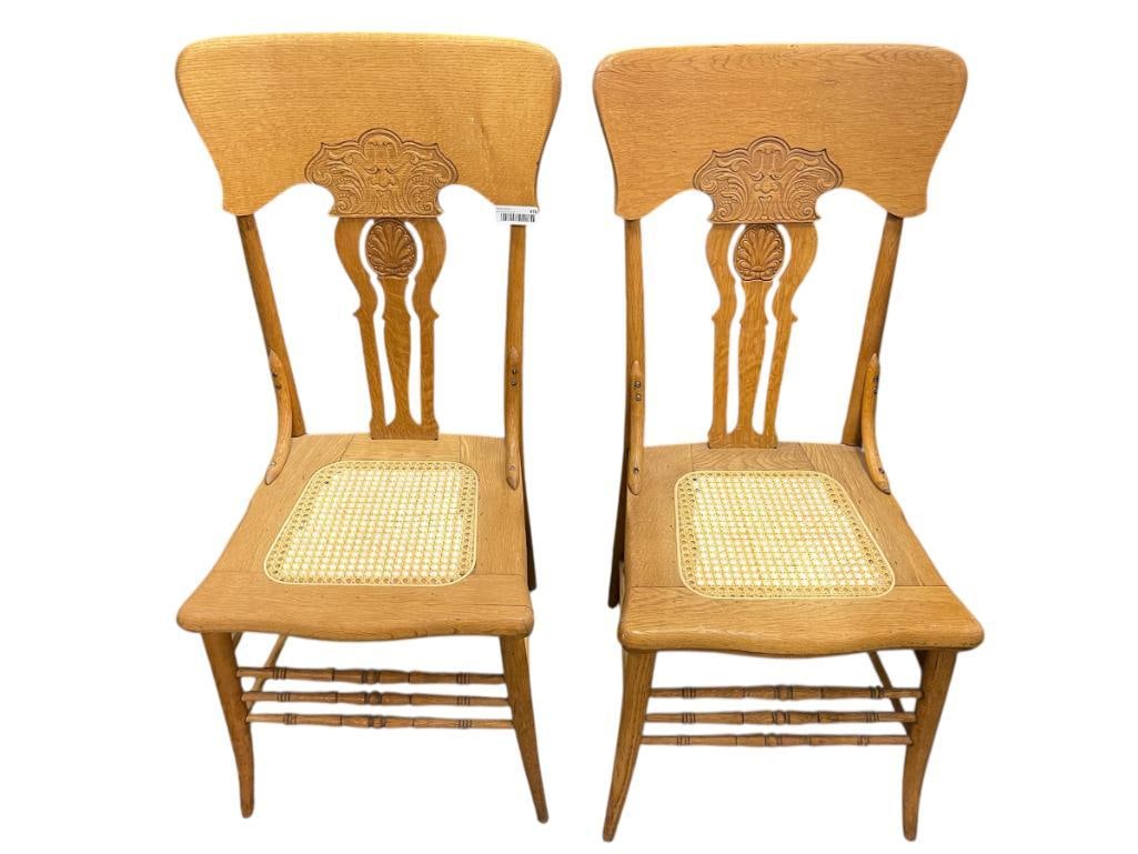 PAIR OF ANTIQUE AMERICAN OAK PRESSED BACK NORTHWIND FACE CARVED CHAIRS WITH CANE SEATS: GOOD CONDITION BUT COULD USE RE-STAINING 18" X 17" X 18" SEAT HEIGHT, 40" SEAT BACK HEIGHT