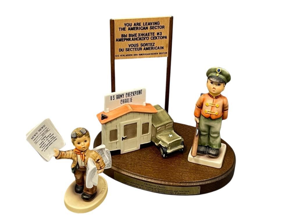 GOEBEL HUMMEL LIMITED EDITION CHECKPOINT CHARLIE AND COMMEMORATIVE EXTRA EXTRA FIGURINE: GOEBEL HUMMEL CHECKPOINT CHARLIE LIMITED EDITION ENSEMBLE FEATURING CHECKPOINT STATION AND FIGURINE WITH BANNER AND WOOD BASE NO. 12,336/20,000, NO. 57 157 10 & 332, ADN EXTRA EXTRA USO COMMEMORAT