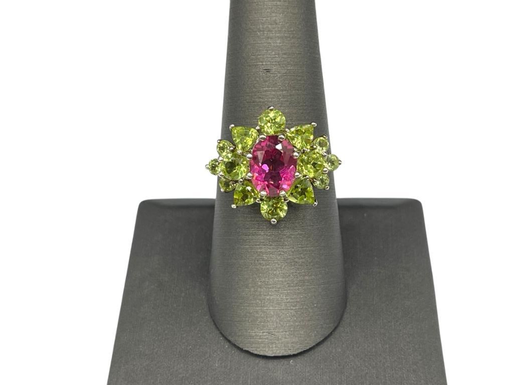 STERLING SILVER PINK SPINEL AND PERIDOT COCKTAIL RING: FEATURING AN OVAL CUT PINK SPINEL ACCENTED BY ROUND AND TRILLION CUT PERIDOT SIZE 8 3/4, 11/16" FRONT, 9MM X 7MM SPINEL, UP TO 4MM PERIDOTS, 4.00 GRAMS