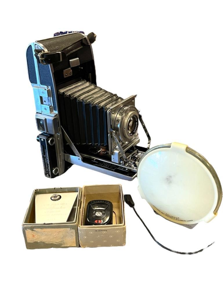 1952-1957 MID-CENTURY POLAROID LAND CAMERA PATHFINDER MODEL 110: BLACK WRAPPED WITH STAINLESS STEEL FRAME, GOOD BELLOWS, OVERALL IN GOOD CONDITION WITH MINIMAL SIGNS OF USE, INCLUDES POLAROID SHUTTER, PATHFINDER TRIPOD ADAPTER WITH ORIGINAL BOX AND POLAROID EXPOSUR