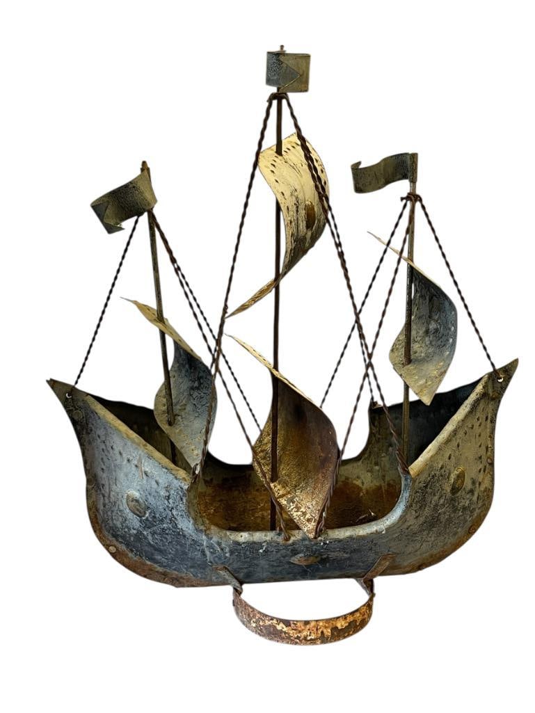 VINTAGE MID-CENTURY BRUTALIST SCHOONER SHIP SCULPTURE: WEATHERED SAILING SHIP WITH MULTIPLE MASTS AND SAILS, HULL SHOWS HEAVY RUST ALONG THE BOTTOM EDGE 18" L, 22" H