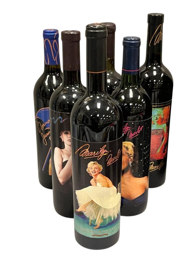 SIX SEALED NAPA VALLY MERLOT MARILYN MONROE COLLECTOR WINE BOTTLES: EACH BOTTLE FEATURES DIFFERENT ILLUSTRATION OF MARILYN MONROE, WORLD RENOWN ACTRESS AND MODEL FROM THE EARLY TO MID 20TH CENTURY, YEARS INCLUDED 1989, 1994, 1996, 2002, AND 2003, ALL BOTTLES ARE SEALE