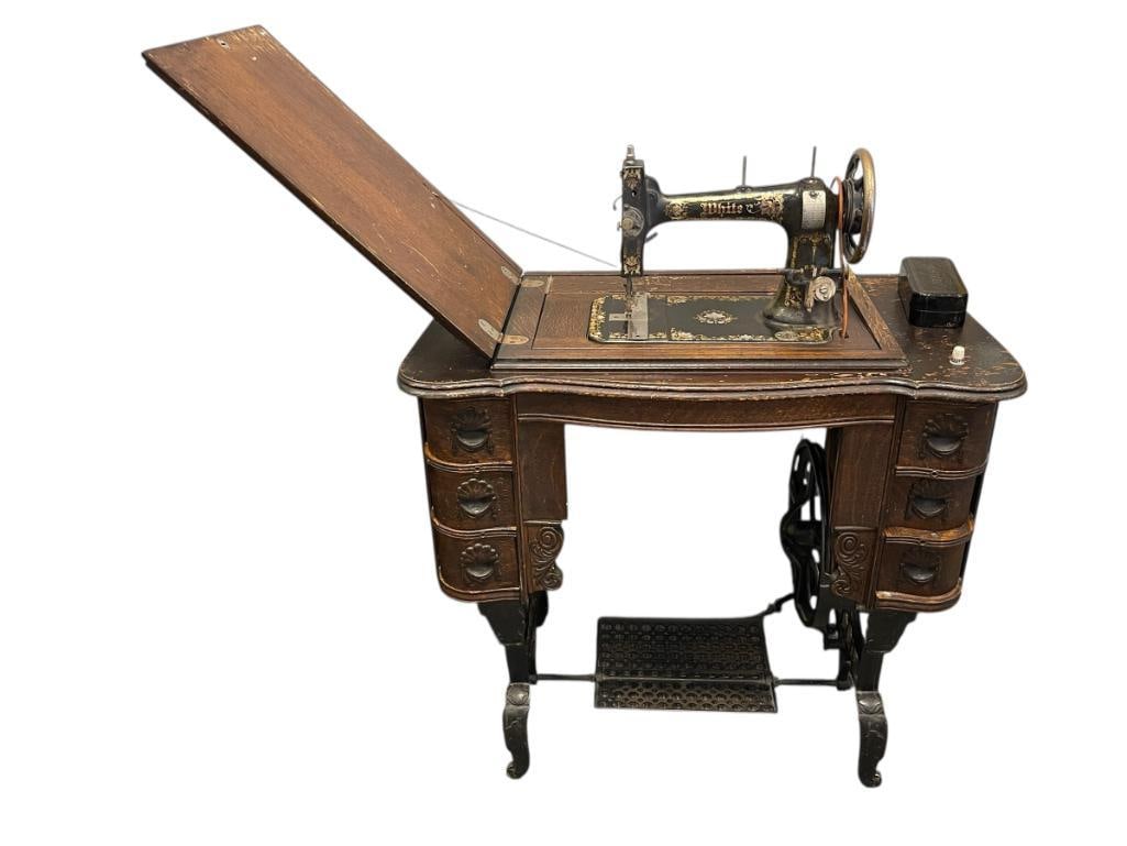 ANTIQUE WHITE TREADLE SEWING MACHINE: LATE 19TH CENTURY EARLY 20TH CENTURY SEWING MACHINE WITH QUARTER SAWN OAK CABINET FEATURING CAST IRON BASE AND SIX DRAWERS, MACHINE IS STUCK IN EXPOSED POSITION WITH TENSION CABLE DAMAGED 33" X 1