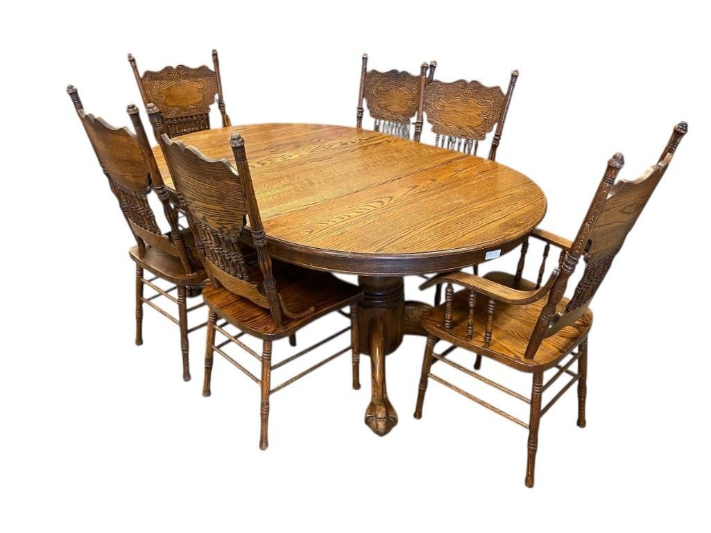 VINTAGE DARK STAINED OAK PEDESTAL CLAW FOOT DINING TABLE WITH SIX PRESSED BACK CHAIRS WITH LEAVES: INCLUDES THREE LEAVES, FOUR SIDE CHAIRS, AND TWO CAPTAINS CHAIRS, OVERALL IN GOOD CONDITION, EACH LEAF HAS ITS OWN STORAGE BAG, TABLE MEASURES 48" ROUND, EACH LEAF EXTENDS TABLE BY 23"