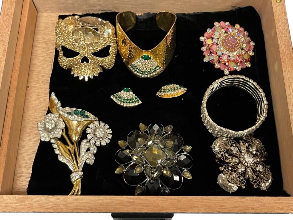 WOMANS RHINESTONE JEWELRY COLLECTION: INCLUDES SIGNED HAMMERED LOOK GOLD TONE BRACELET, SKULL BROOCH, STRETCH BRACELET, STYLIZED CROSS BROOCH, CLIP-ON EARRINGS, NINE PIECES TOTAL, INCLUDES GOODMAN CARBON FIBER LOOK VENEER CIGAR BOX /