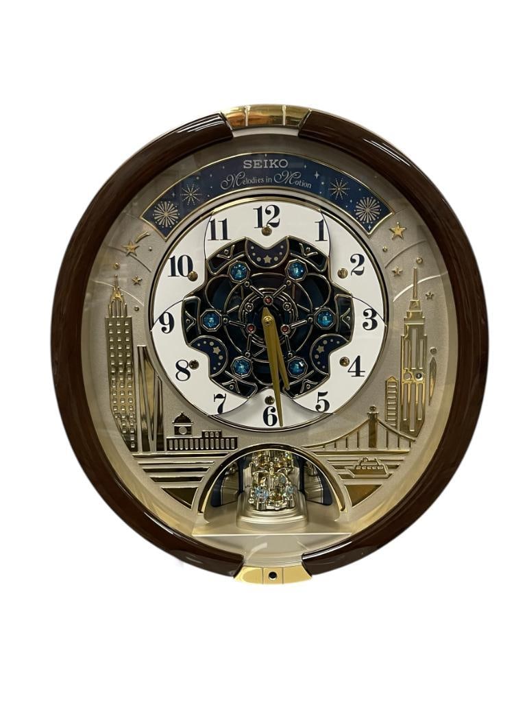 SEIKO MELODIES IN MOTION BATTERY OPERATED ANIMATED WALL CLOCK WITH SWAROVSKI CRYSTALS: 2019 SPECIAL EDITION MOTION WALL CLOCK FEATURES A CITYSCAPE MOTIF WITH FAMOUS LANDMARKS SUCH AS THE EMPIRE STATE BUILDING, DIAL SPLITS AND ROTATES WHEN MUSIC PLAYS, PLAYS 30 DIFFERENT MELODIES,