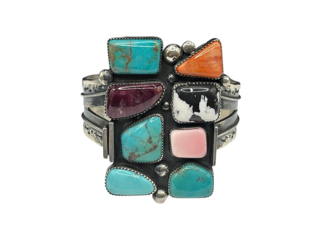 NAVAJO MARCUS CHAVEZ ARTIST SIGNED STERLING SILVER MULTI-STONE CUFF BRACELET FEATURING TURQUOISE: INCLUDES VARIOUS TYPES OF TURQUOISE, WHITE BUFFALO, SPINY OYSTER, AND MORE, STAMPED PATTERN ON CUFF, SIGNED BY ARTIST "MARCUS C." 2 1/2" CUFF WIDTH, 2 1/2" FRONT, 100.00 GRAMS 