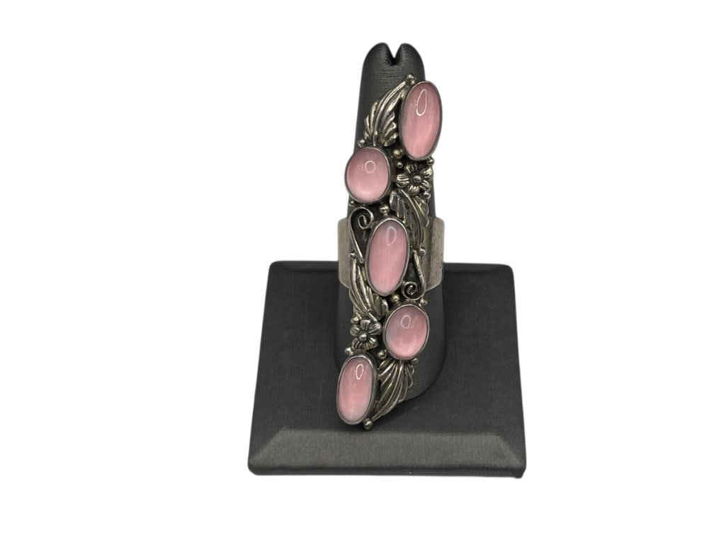 VINTAGE NAVAJO ARTIST SIGNED STERLING SILVER PINK MOONSTONE RING FEATURING TOOLED SILVER DESIGN: RING FEATURES FIVE OVAL CABOCHON PINK MOONSTONES AND ORNATE TOOLED FOLIATE DESIGN SIZE 9 1/2, 2 5/8" FRONT, 19.95 GRAMS
