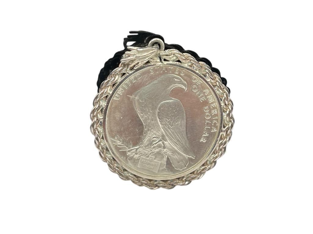 1984 U.S. OLYMPIC LIBERTY SILVER DOLLAR ENCASED IN STERLING SILVER PENDANT: 1984 LOS ANGELES XXIII OLYMPIAD COMMEMORATIVE COIN, 90% SILVER COIN 35.82 GRAMS, 2 1/4" WITH BAIL