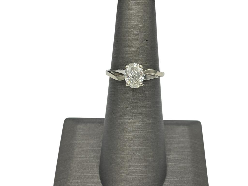 14K WHITE GOLD DIAMOND SOLITAIRE RING FEATURING AN OVAL CUT DIAMOND: FEATURING A PRONG SETTING WITH PIERCED DESIGN ON SHOULDERS OF SHANK, NOT GRADED FOR CUT OR CLARITY SIZE 5 1/2, 1.50CT DIAMOND, 2.50 GRAMS 