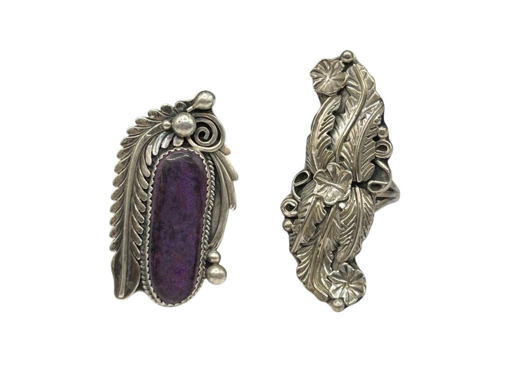 TWO VINTAGE NAVAJO STERLING SILVER TOOLED SILVER RINGS INCLUDING ONE WITH SUGILITE: OTHER FEATURES ORNATELY TOOLED SQUASH BLOSSOM AND FEATHER DESIGN, BOTH HALLMARKED BY ARTIST INCLUDING ONE SIGNED JOE IN OVAL AND OTHER SIGNED RB IN BEAR FETISH SIZE 7 AND 8, UP TO 2" FRONTS, 23.49