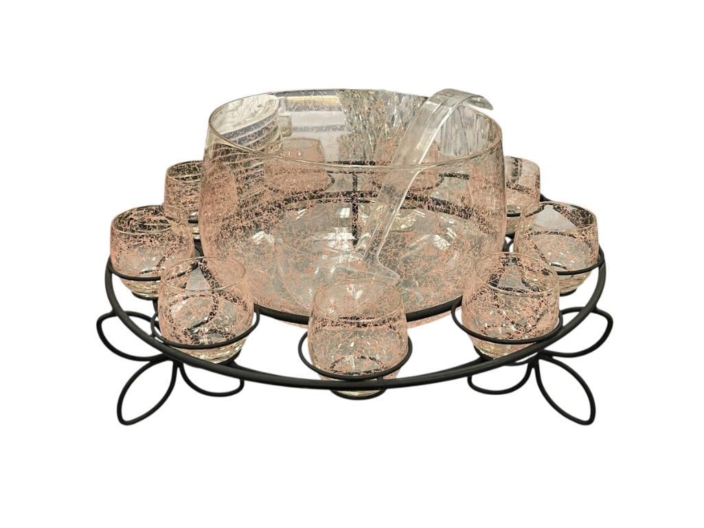 CLEAR GLASS AND PINK PLATTER PUNCHBOWL AND MUGS WITH BLACK METAL WIRE STAND AND ACRYLIC LADDLE: INCLUDES NINE CUPS, FLORAL DESIGN METAL STAND 15" ROUND STAND, 9" PUNCHBOWL, 2 1/2" CUPS