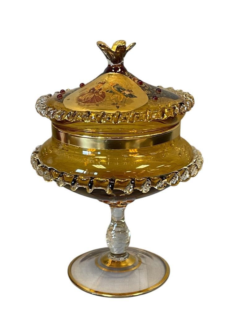 20TH CENTURY HAND BLOWN AMBER GLASS REGENCY STYLED PEDESTAL CANDY DISH WITH EMBELLISHMENTS: AMBER AND CLEAR IN COLOR WITH GILT DESIGN AND DECORATED WITH GLASS BEADS, FEATURES COLOR AND GILT IMAGE OF FRENCH COLONIAL COUPLE DANCING ON THE TOP LID, LIGHT WEAR TO GILDING, NO CHIPS OR CRACKS 7