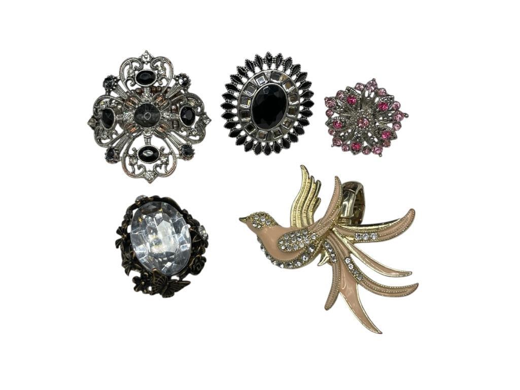 FIVE ASSORTED COSTUME JEWELRY RINGS INCLUDING STARBURST DESIGN AND MORE: ELASTIC BANDS FOR ADJUSTABLE SIZE 