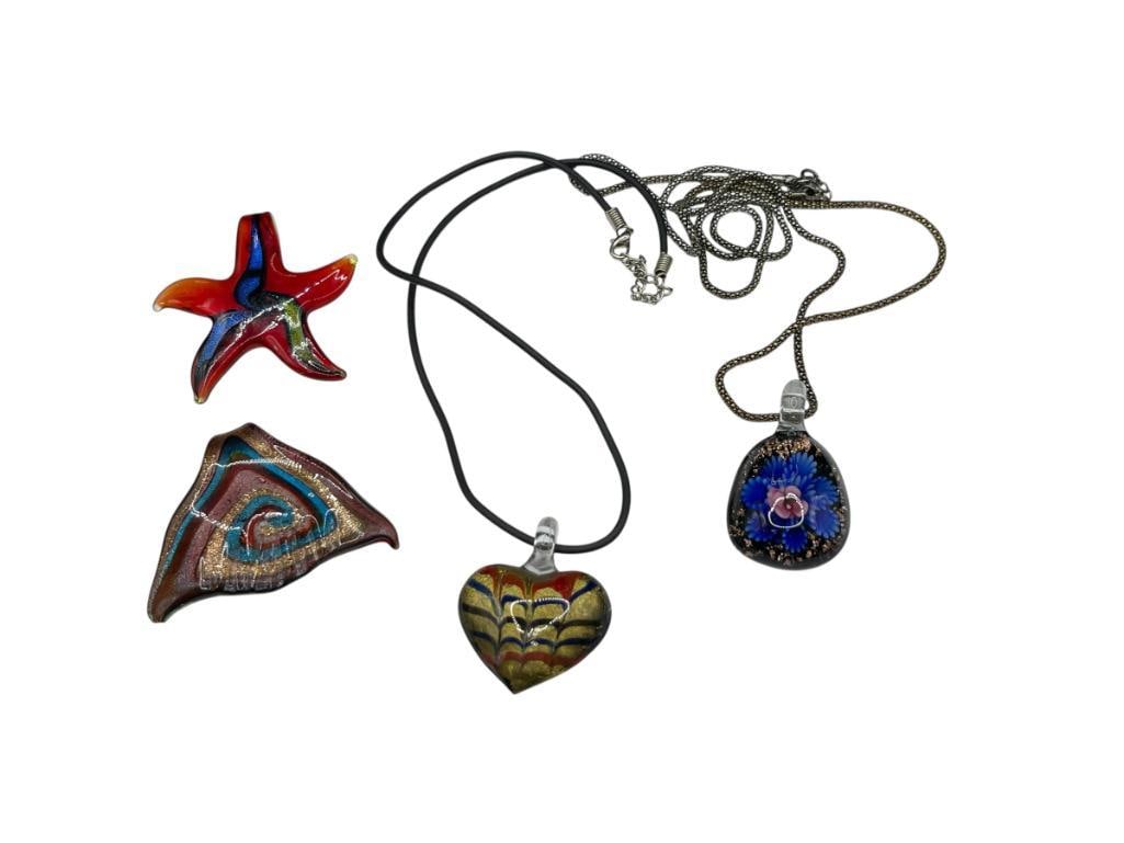 FOUR ART GLASS PENDANTS INCLUDING STARFISH, HEART, FLOWER, AND TRIANGULAR DESIGNS: INCLUDES TWO WITH NECKLACES, TRIANGULAR PENDANT HAS CHIP ON CORNER LARGEST PENDANT IS 2 3/8" 