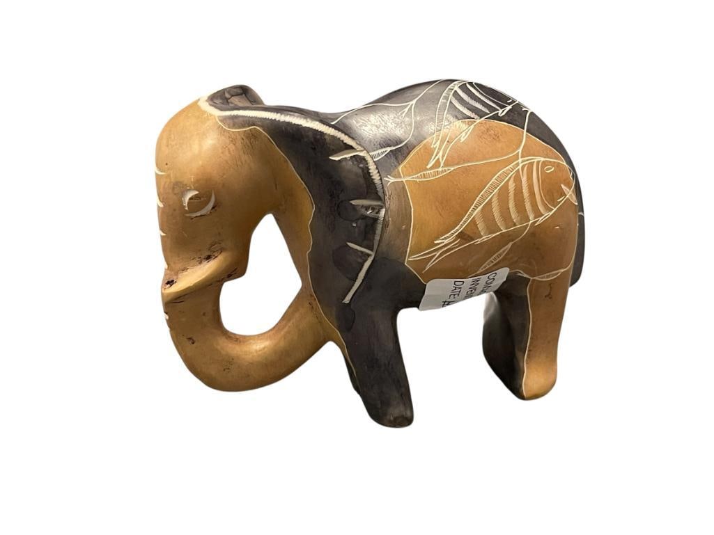 HEAY CARVED SOAPSTONE ELEPHANT FIGURINE WITH FISH CARVINGS ON ITS BACK: BROWN AND INDIGO IN COLOR, LIGHT WEAR ON THE BOTTOM OF ITS FEET 5 1/4" L 