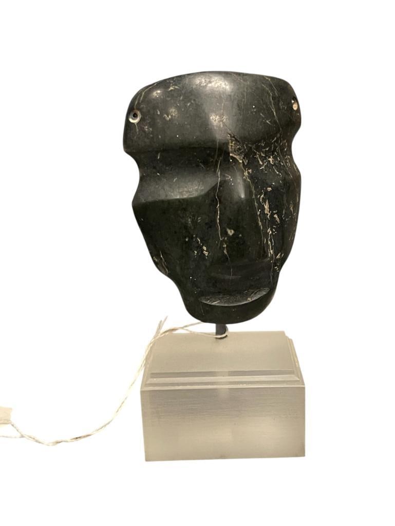 PRE-COLUMBIAN MESOAMERICAN HAND-CARVED DEEP BLACK AGATE MASK: STYLIZED MASK WITH CLOSED EYES AND SERENE EXPRESSION, MOUNTED ON METAL ROD WITH FROSTED STEPPED ACRYLIC BASE 4 3/4" H 