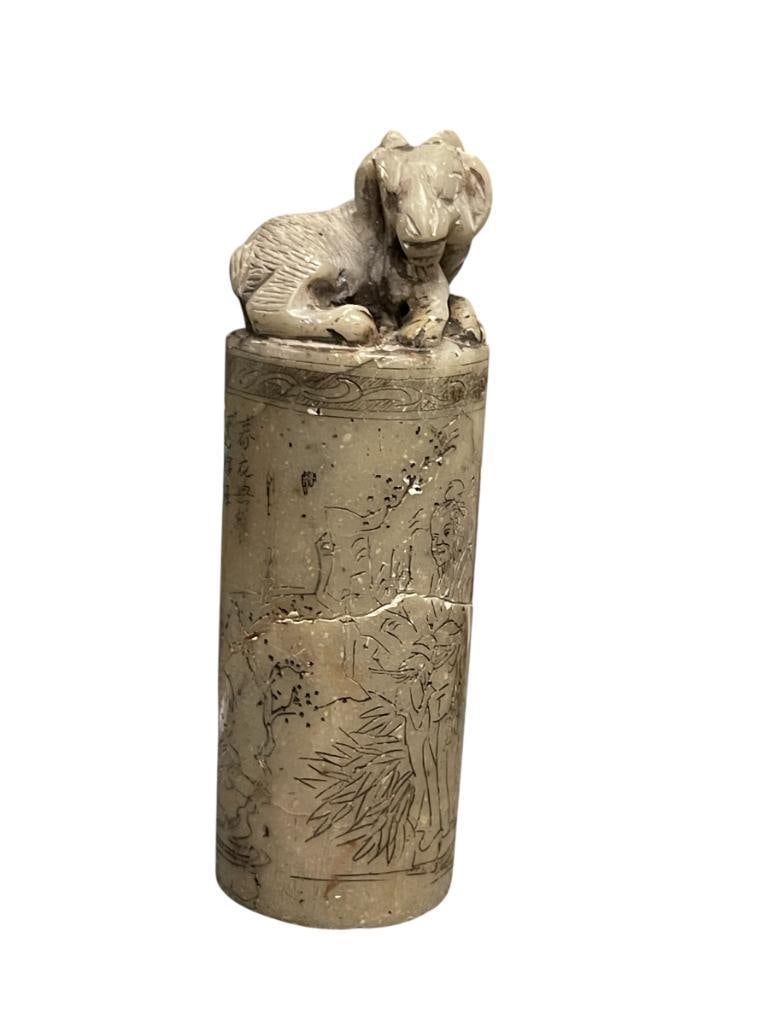 ANTIQUE 19TH CENTURY CHINESE HAND-CARVED GREY STONE CHOP SEAL WITH SCULPTED ANIMAL TOP: LARGE CYLINDRICAL CHOP SEAL IN GREY STONE WITH CARVING ALONG THE BODY OF A SCHOLAR AND CHILD PLAYING IN A LANDSCAPE WITH CARVED CHARACTERS AND UPPER BAND, RAM CARVED FIGURE ON TOP, HAS BEEN