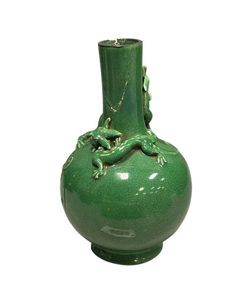 LATE 19TH CENTURY MONOCHROME PORCELAIN VASE, GREEN CRACKLED GLASE WITH DRAGONS ON THE NECK: GOURD SHAPED VASE WITH TWO DRAGONS WRAPPED AROUND THE NECK, DARK GREEN CRACKLED GLAZE, NO MARKINGS, RIM HAS BEEN PREVIOUSLY REPAIRED, AND A HORN ON ONE OF THE DRAGONS IS MISSING 6 3/4" H 