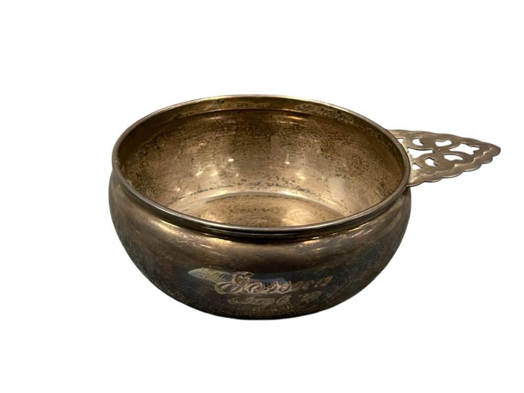 20TH CENTURY STERLING SILVER CHILDRENS PORRIDGE BOWL WITH PIERCED HANDLE HALLMARKED 128 GRAMS: ENGRAVED ON THE BODY "JESSICA AUG. 6, '49", FEW SMALL DENTS ALONG THE BODY, MARKED ON THE BOTTOM, TOTAL WEIGHT OF 128 GRAMS 4 1/2" ROUND 