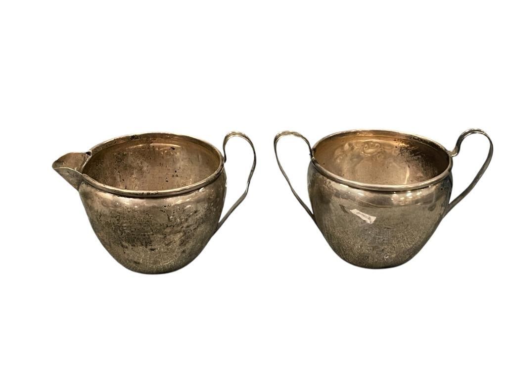 20TH CENTURY THE NATIONAL SILVER CO. STERLING SILVER CREAMER AND SUGAR BOWL 108 GRAMS: STERLING SILVER HOLLOWARE CREAMER AND SUGAR, BOTH HAVE MANY DENTS, TOTAL WEIGHT 108 GRAMS, HALLMARKED ON THE BOTTOM, NO MONOGRAM 2 3/8" H 