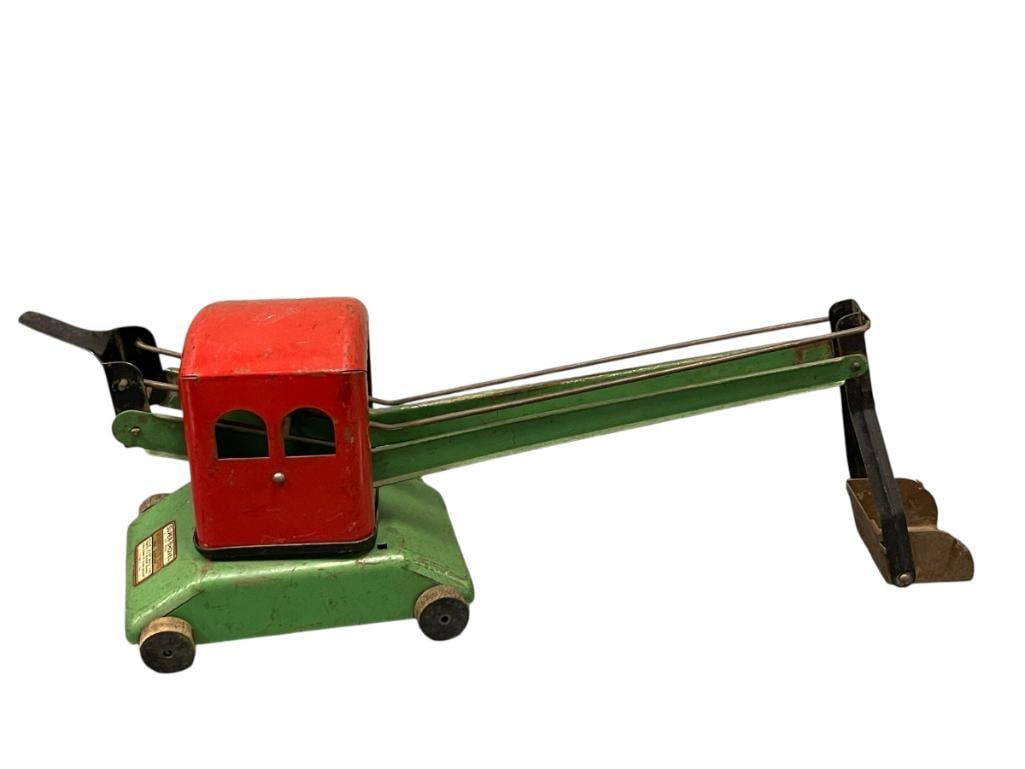 1930'S WYANDOTTE TOYS SUPER-SHOVEL PRESSED STEEL TOY STEAM SHOVEL: RED AND GREEN BODY WITH BLACK STAINED WOODEN WHEELS, ALL WHEELS INTACT, ORIGINAL LABEL ON THE BACK OF THE TOY LEGIBLE, MADE IN THE U.S.A., COMPLETE WITH OBVIOUS PAINT WEAR AND SURFACE RUST 16" L 