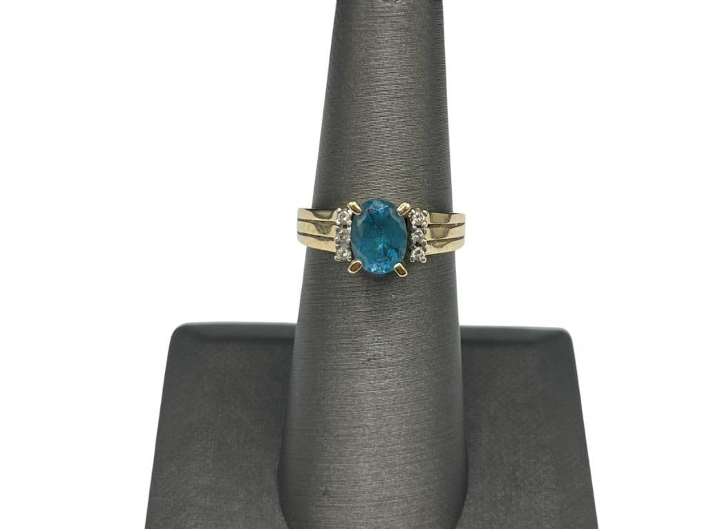 10K YELLOW GOLD OVAL CUT LONDON BLUE TOPAZ AND DIAMOND RING: FEATURING SIX ROUND BRILLIANT CUT DIAMONDS SIZE 6 1/4, 8MM X 6MM TOPAZ, 1MM DIAMONDS, 4.15 GRAMS 