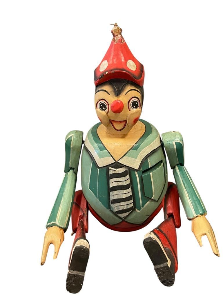 LATE 20TH CENTURY WHIMSICAL HAND CRAFTED JOINTED WOOD PINOCCHIO COIN BANK DOLL: HAND CARVED, HAND PAINTED PINOCCHIO COIN BANK DOLL, MADE IN INDONESIA, TOP OF THE HAT HAS DAMAGE 18 1/2" TOTAL HEIGHT 