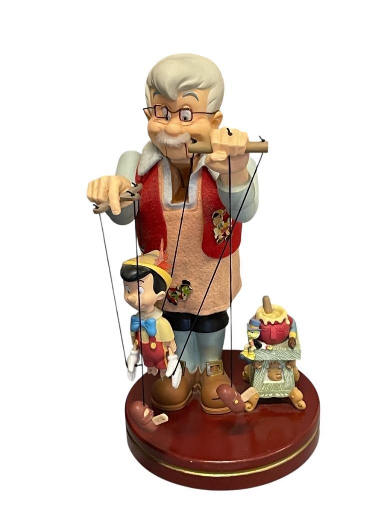 GEPETTO HOLDING PINOCCHIO MARIONETTE DOLL WITH SEATED JIMINY CRICKET NEARBY LARGE FIGURINE: MOUNTED ON ROUND BASE, PINOCCHIO LEGS ARE MISSING PINS 14" H 