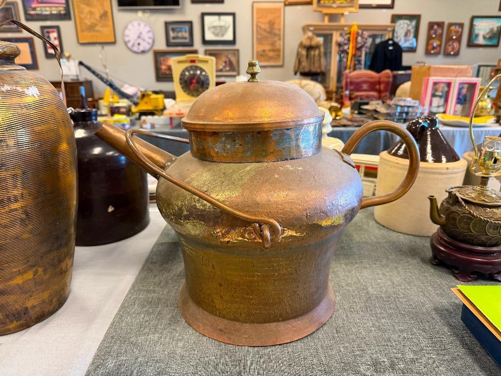 LARGE ANTIQUE HAND HAMMERED COPPER STOVE TOP KETTLE DOVETAIL CONSTRUCTION: LARGE BODY KETTLE WITH ROUND BASE, LARGE FIXED HANDLE AND SWIVEL HANDLE, INCLUDES TOP WITH BRASS HANDLE, TAPERED SPOUT, SHOWS SEVERAL AREAS WHERE IT HAS BEEN PREVIOUSLY REPAIRED 15" H, 20" SPOUT TO