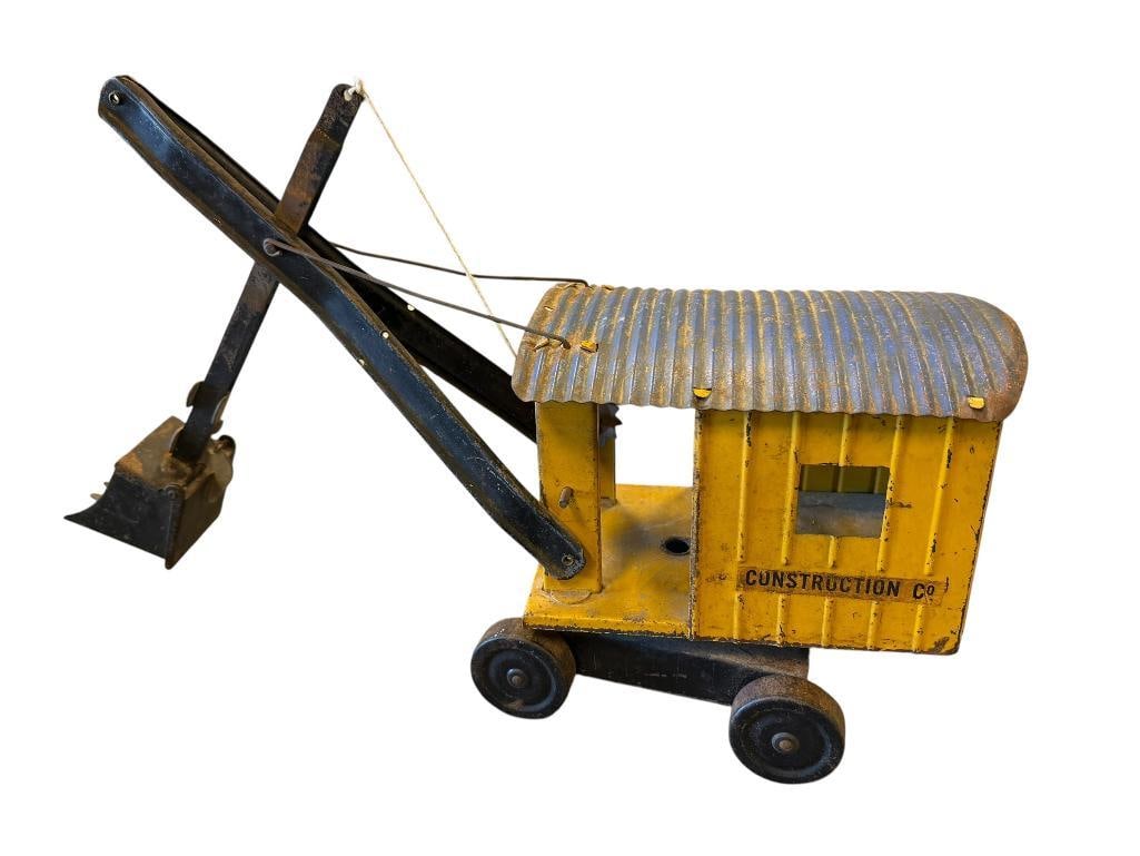 1930'S - 1940'S STRUCTO TOYS PRESSED STEEL STEAM SHOVEL CONSTRUCTION CO.: CORRUGATED CAB IN YELLOW WITH HAND CRANK SHOVEL, ALL WHEELS INTACT, ORIGINAL LABELS PRESENT, COMPLETE TOY, BUT DOES SHOW PAINT WEAR AND AGE 18" L