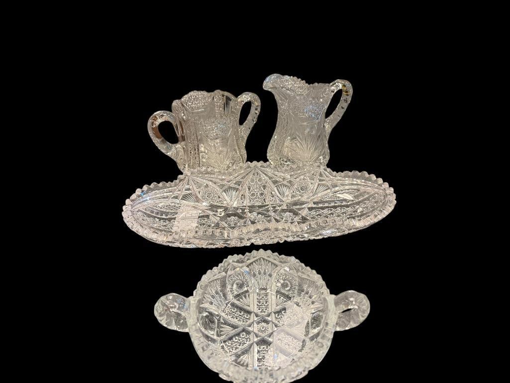 ANTIQUE CUT AND PRESSED GLASS TABLEWARE INCLUDING CREAMERS, CELERY DISH, AND HANDLED SUGAR BOWL: SME MINOR CHIPS AROUND RIMS ON A COUPLE PIECES LARGEST IS 11 1/2" L 