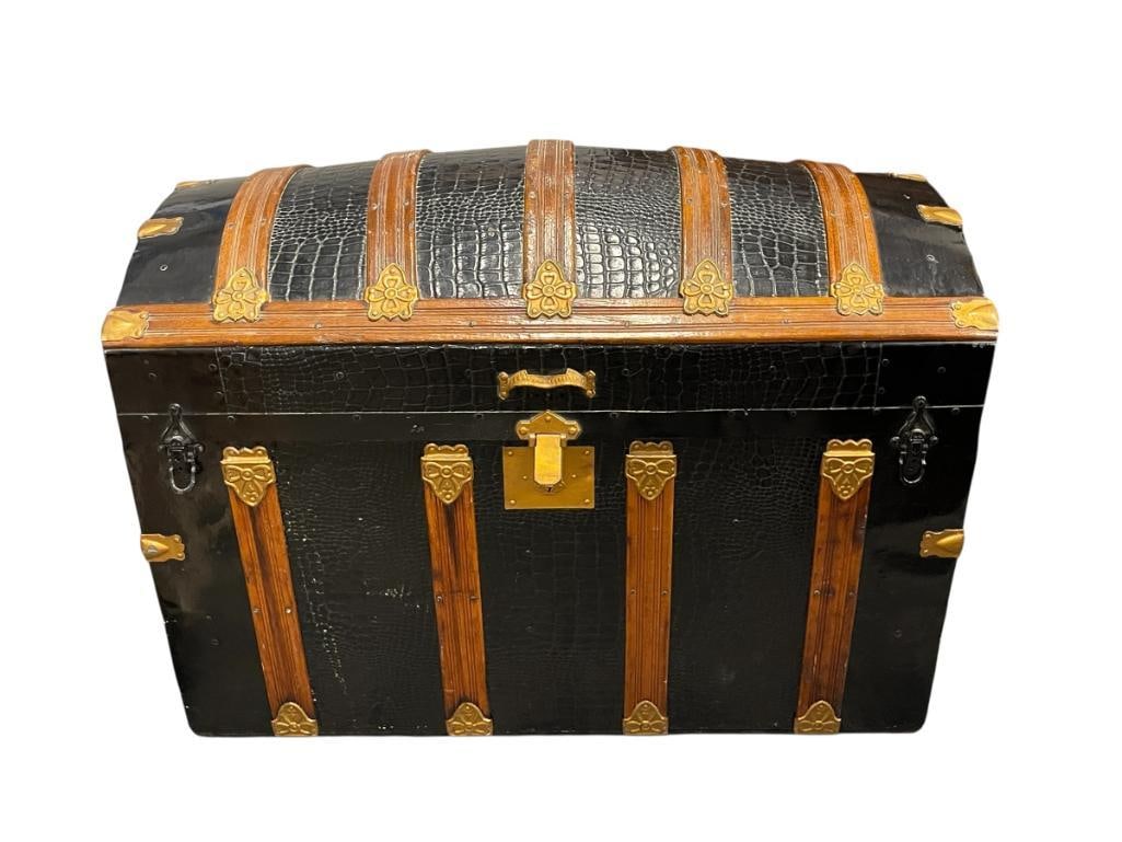 NICELY RESTORED ANTIQUE CAMEL BACK TRUNK ALLIGATOR METAL OVERLAY: BLACK AND GOLD IN COLOR WITH NATURAL WOOD TRIM, THICK LEATHER HANDLES, INTERIOR HAS BEEN REFINISHED, FEATURES REMOVABLE TRAY WITH STORAGE COMPARTMENTS, HINGED TOP ALSO FEATURES STORAGE COMPARTMEN