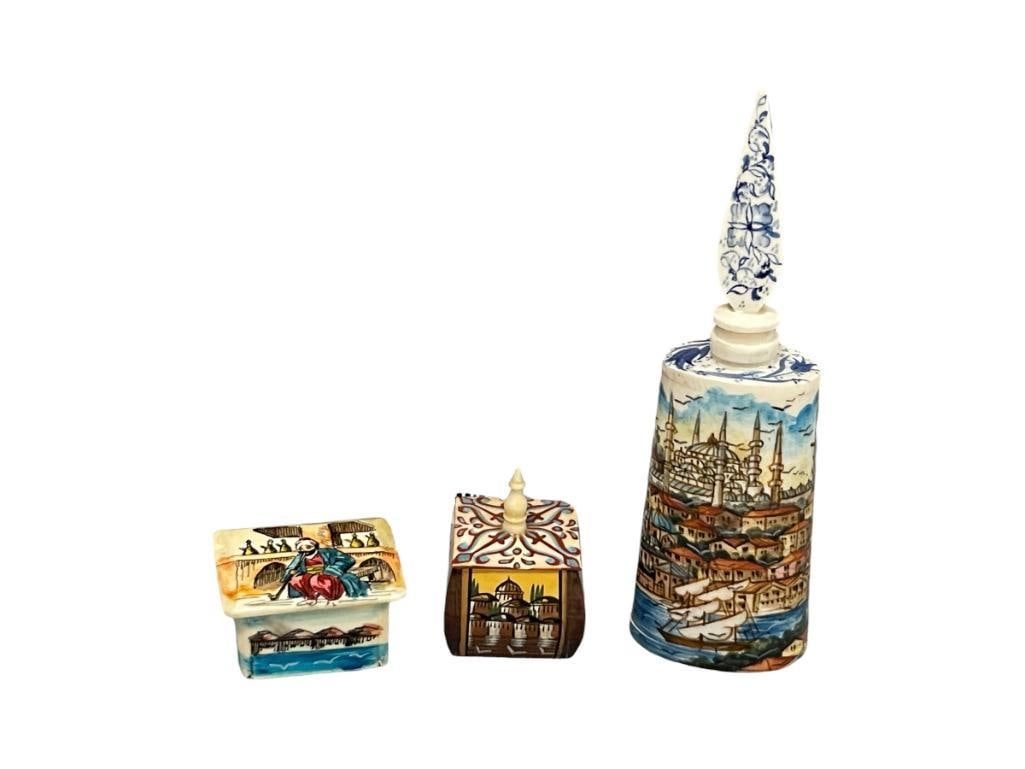 20TH CENTURY HAND CARVED CAMEL BONE TRINKET BOXES AND PERFUME BOTTLES FROM ISTNBUL: TWO HAND PAINTED LIDDED TRINKET BOXES WITH CITY SCENES AND TALL HAND PAINTED PERFUME BOTTLE WITH STOPPER FEATURING CITY SCENES 1 1/4" AND 1 1/2" TRINKET BOXES AND 5 1/2" PERFUME BOTTLE
